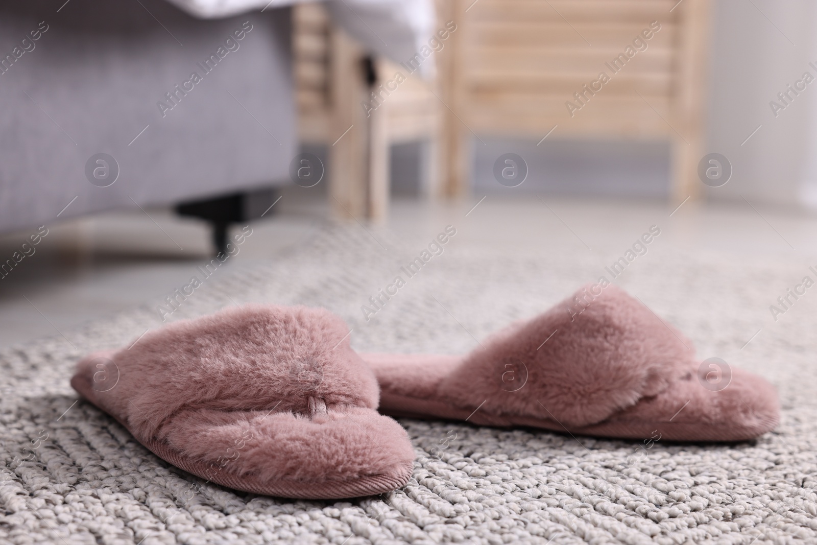 Photo of Pink soft slippers on carpet at home, closeup