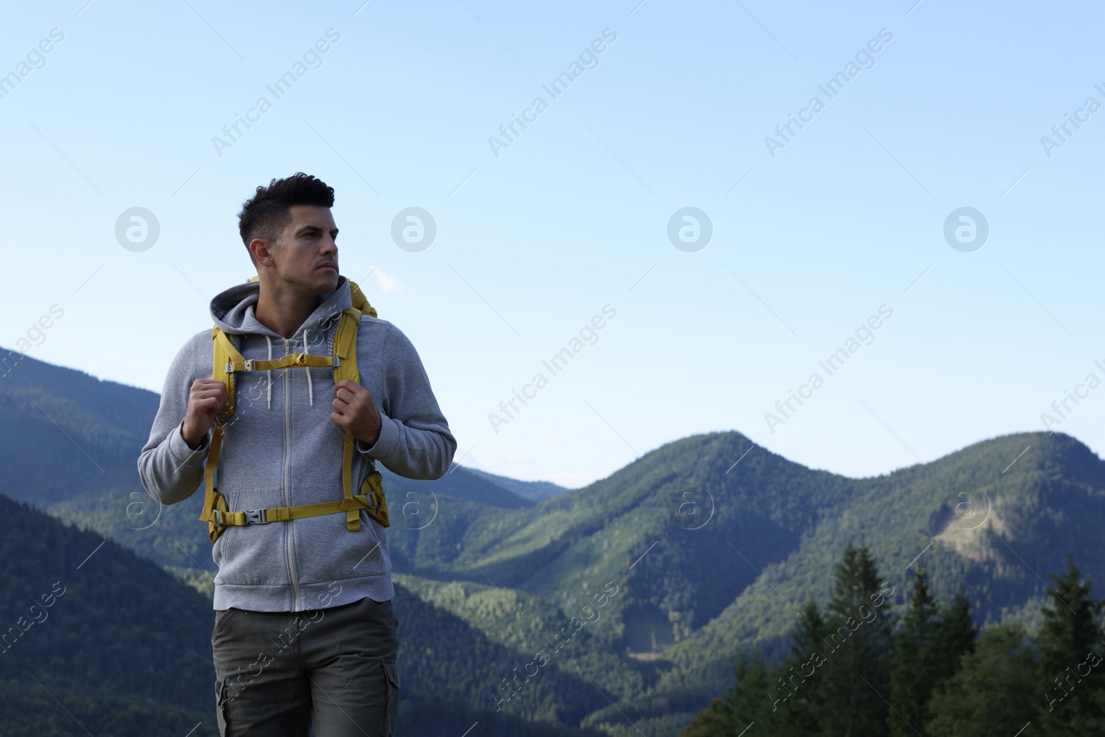 Photo of Tourist with backpack in mountains, space for text