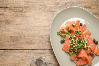 Delicious salmon carpaccio served on wooden table, top view. Space for text