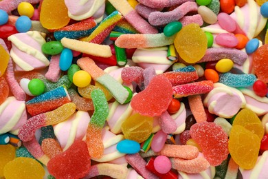 Different tasty candies as background, top view