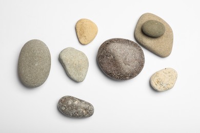 Photo of Many different stones on white background, top view