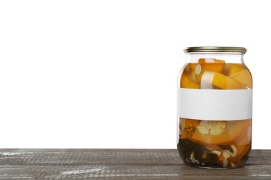 Photo of Jar of pickled yellow sliced zucchini with blank label on wooden table against white background. Space for text