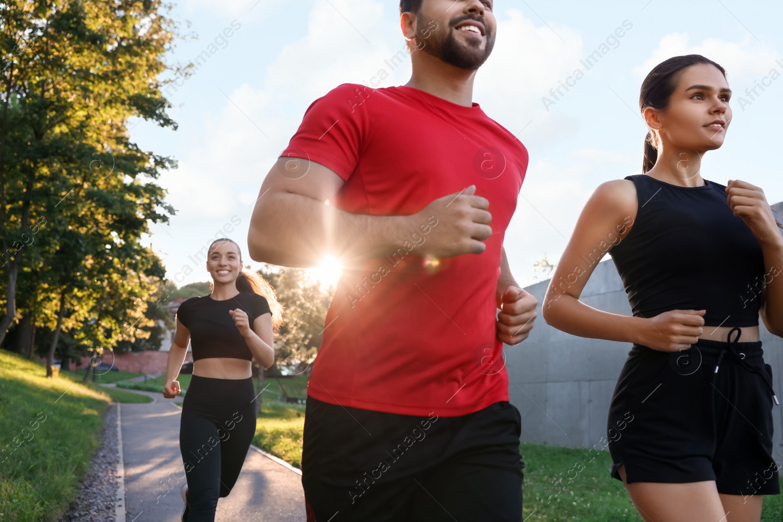 Photo of Group of people running outdoors on sunny day