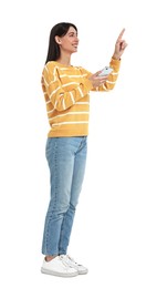 Photo of Happy woman using smartphone and pointing at something on white background