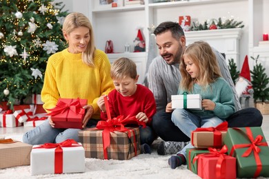 Parents and their children opening Christmas gifts at home