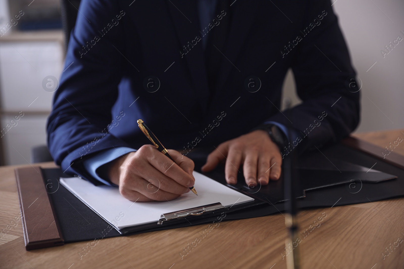 Photo of Male lawyer working at table in office, closeup