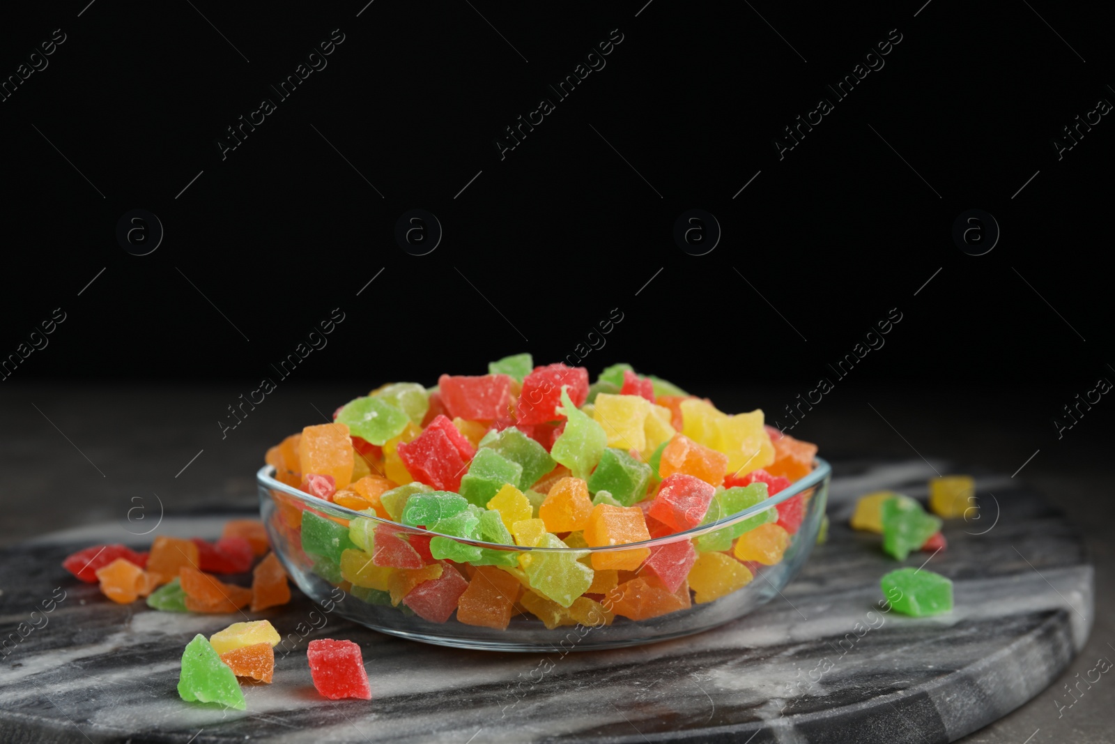 Photo of Mix of delicious candied fruits on marble board, space for text