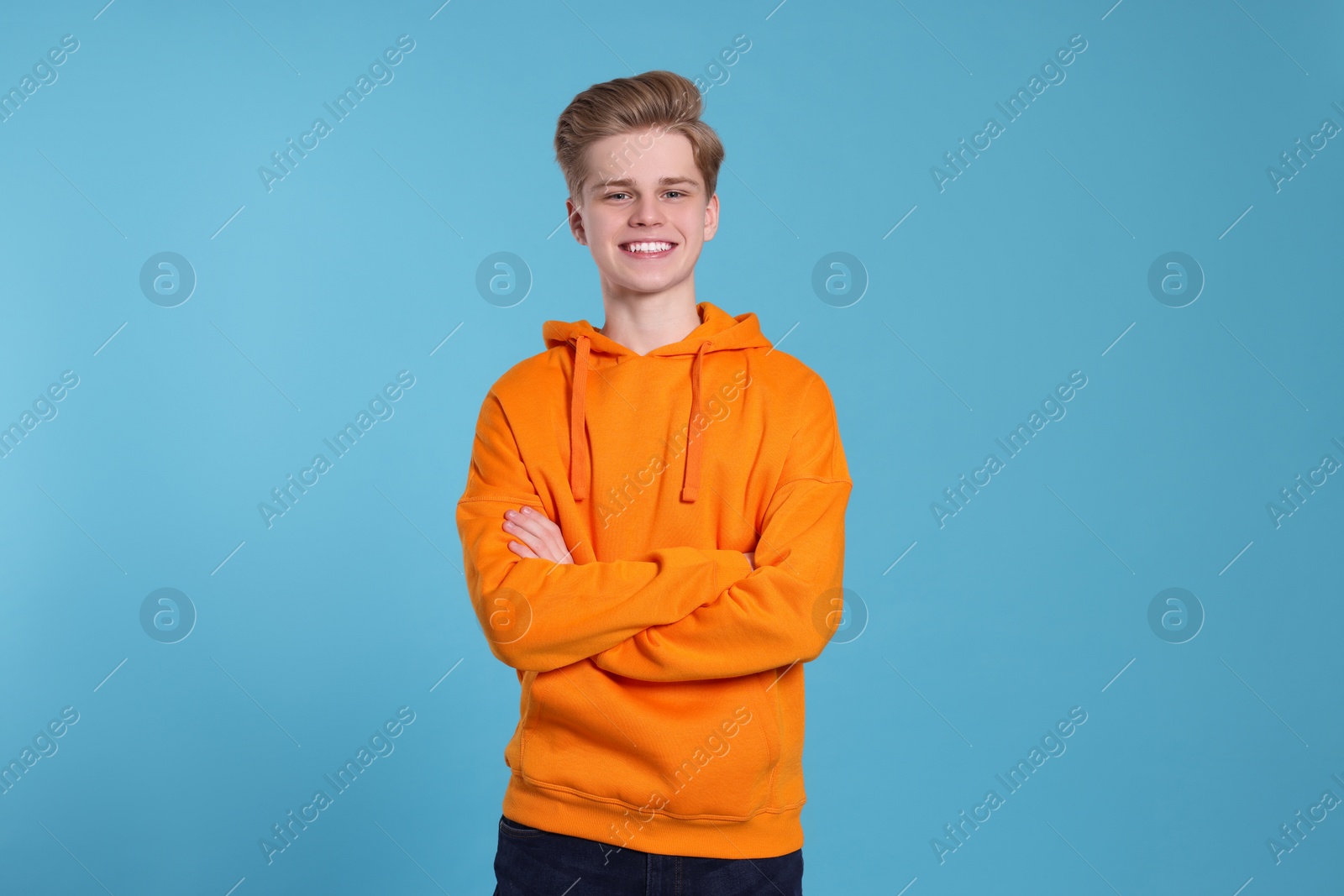 Photo of Portrait of smiling teenage boy on light blue background