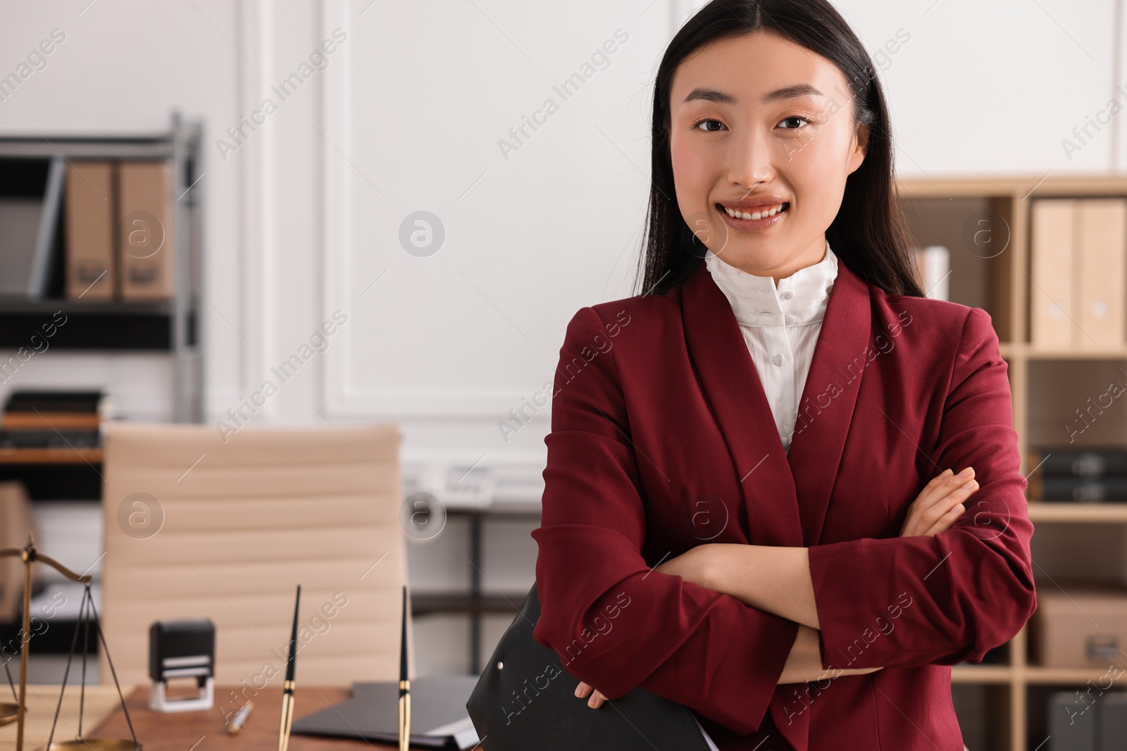 Photo of Portrait of smiling notary with crossed arms in office. Space for text