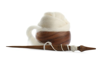 Photo of Ball of combed wool with wooden spindle and bowl isolated on white