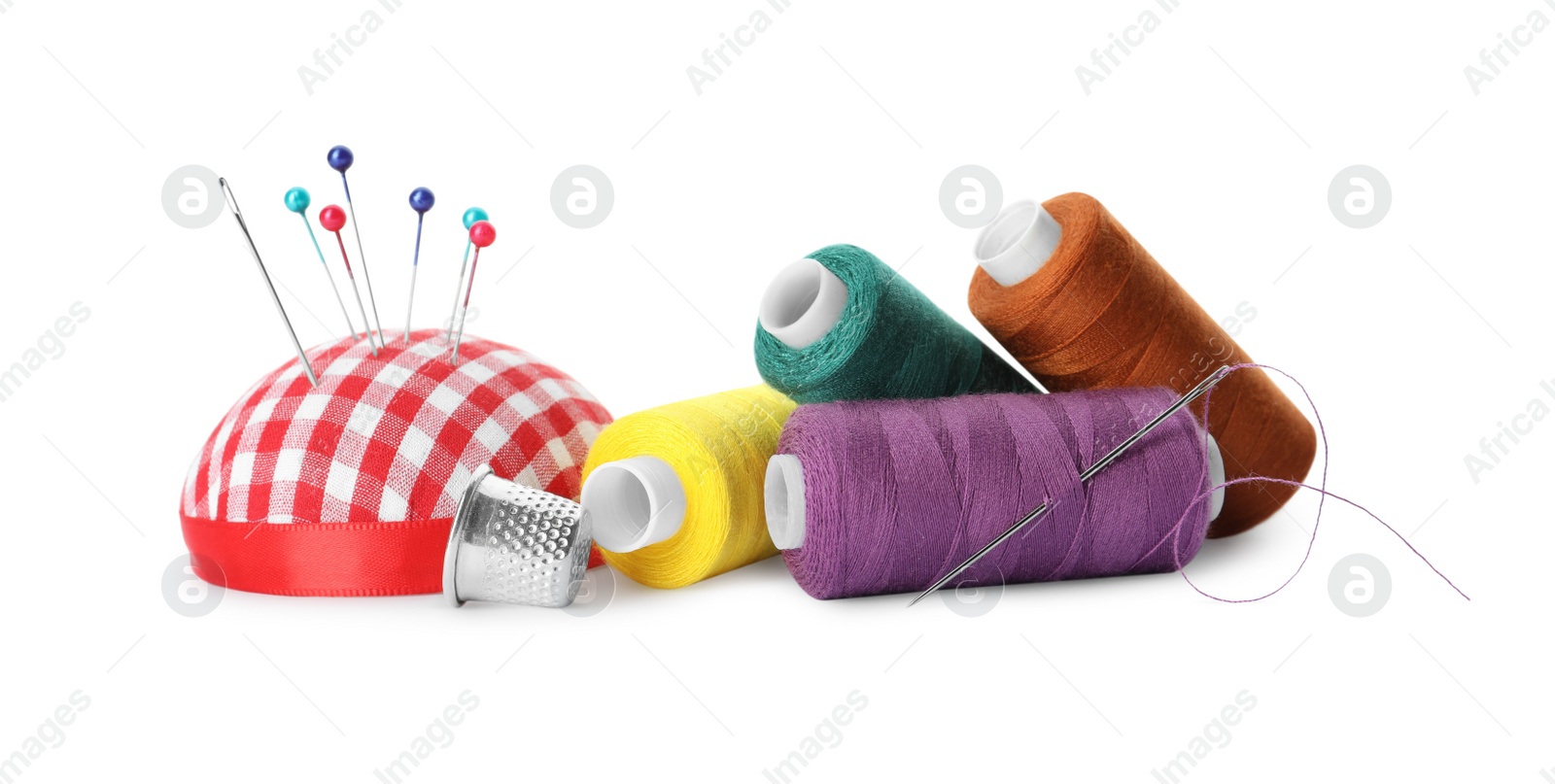 Photo of Spools of threads and sewing tools on white background