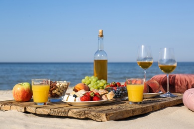 Photo of Food and drinks on beach. Summer picnic
