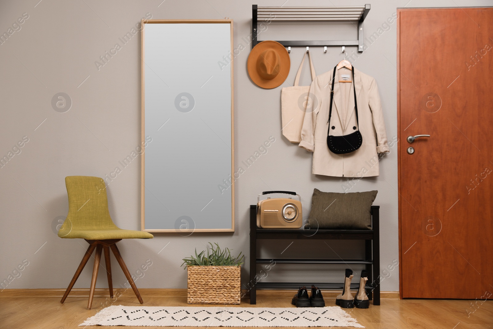 Photo of Modern hallway interior with stylish chair, shoe rack and mirror