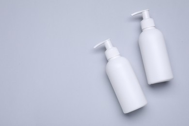 Different cleansers on light grey background, flat lay and space for text. Cosmetic product