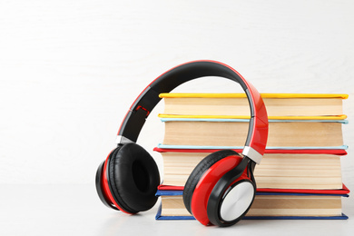 Books and modern headphones on white background. Space for text