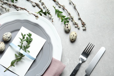 Photo of Festive Easter table setting with quail eggs on color background, flat lay