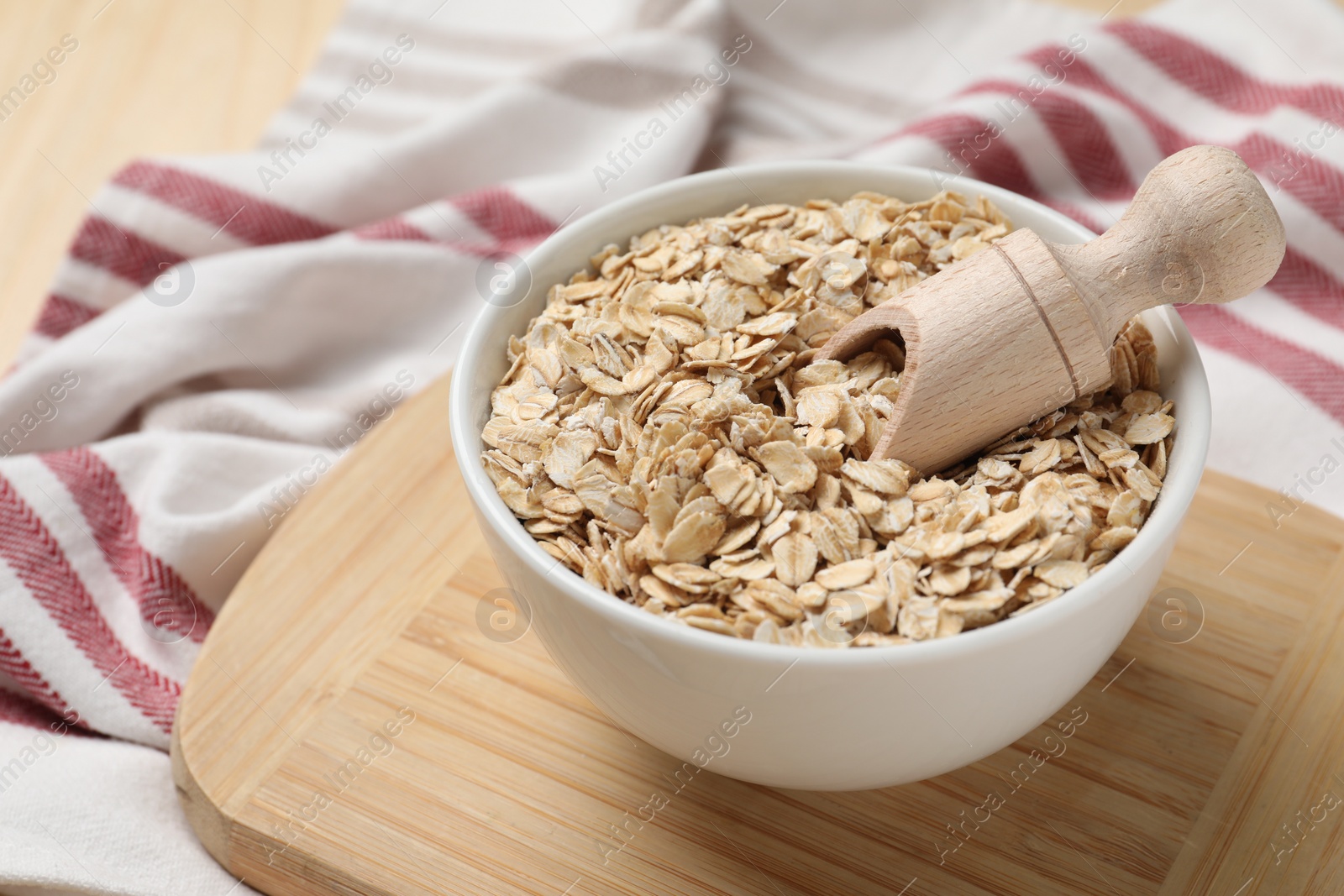 Photo of Bowl and scoop with oatmeal on table