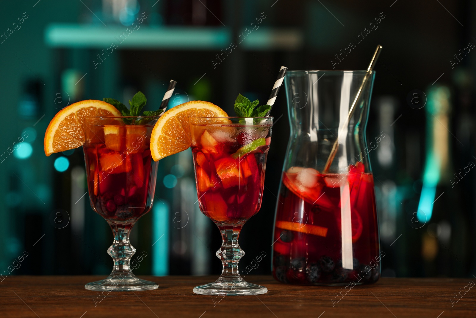 Photo of Delicious sangria cocktail on wooden table in bar
