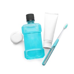 Mouthwash, toothbrush, paste and dental floss on white background, top view