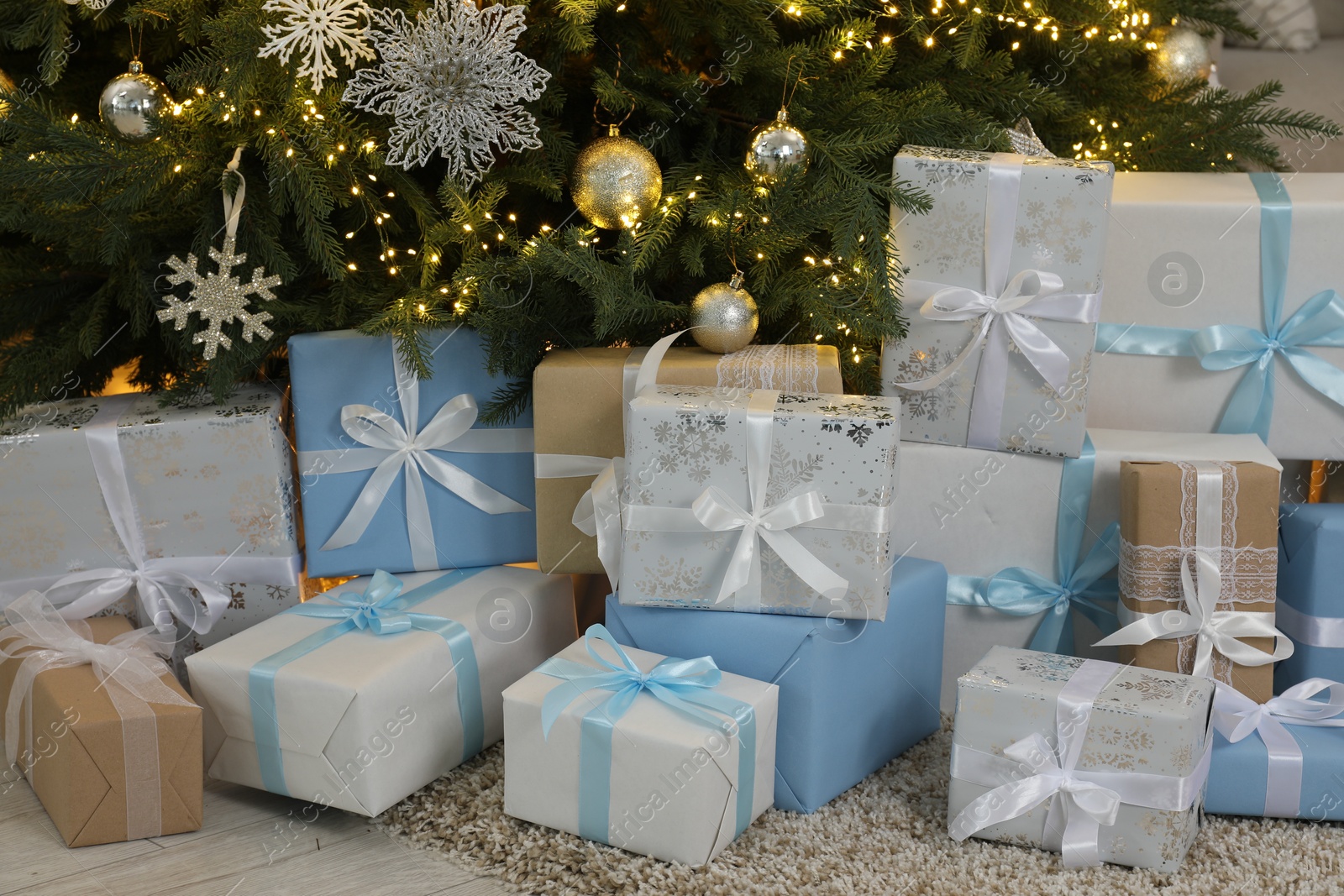 Photo of Many gift boxes under beautiful Christmas tree on floor at home