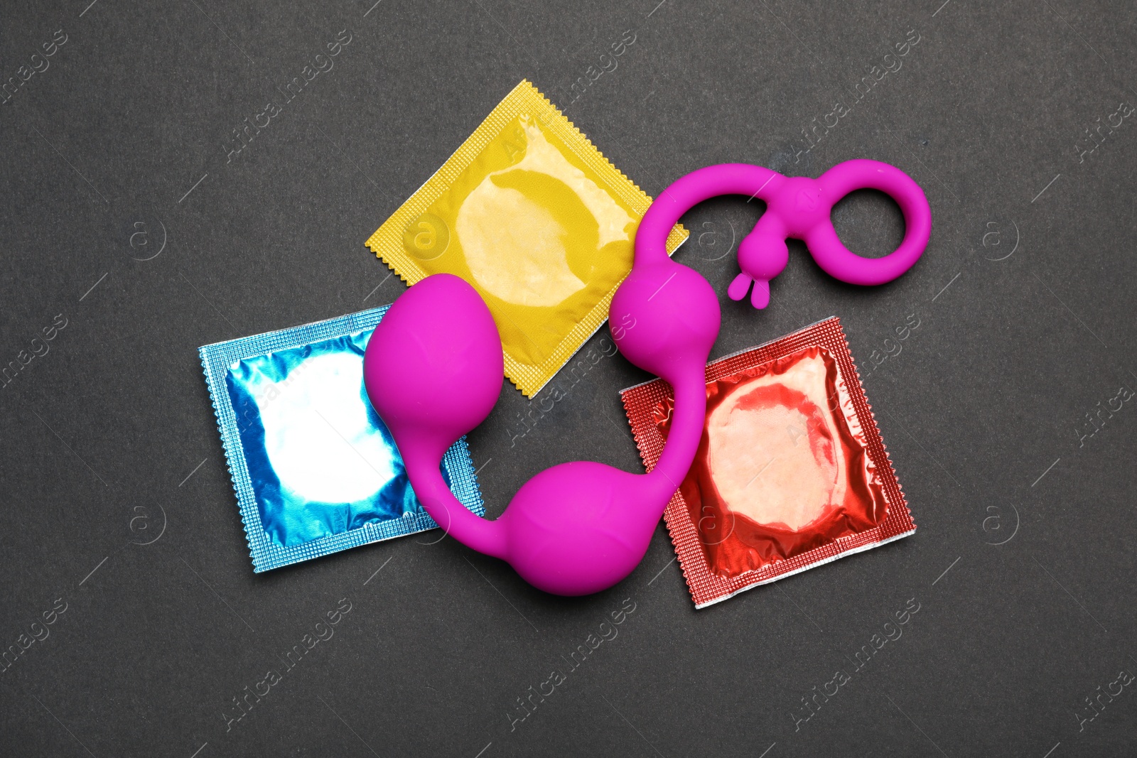 Photo of Anal balls and condoms on black background, top view. Sex game