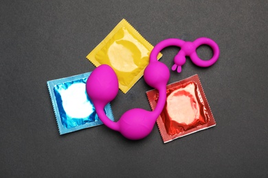 Photo of Anal balls and condoms on black background, top view. Sex game