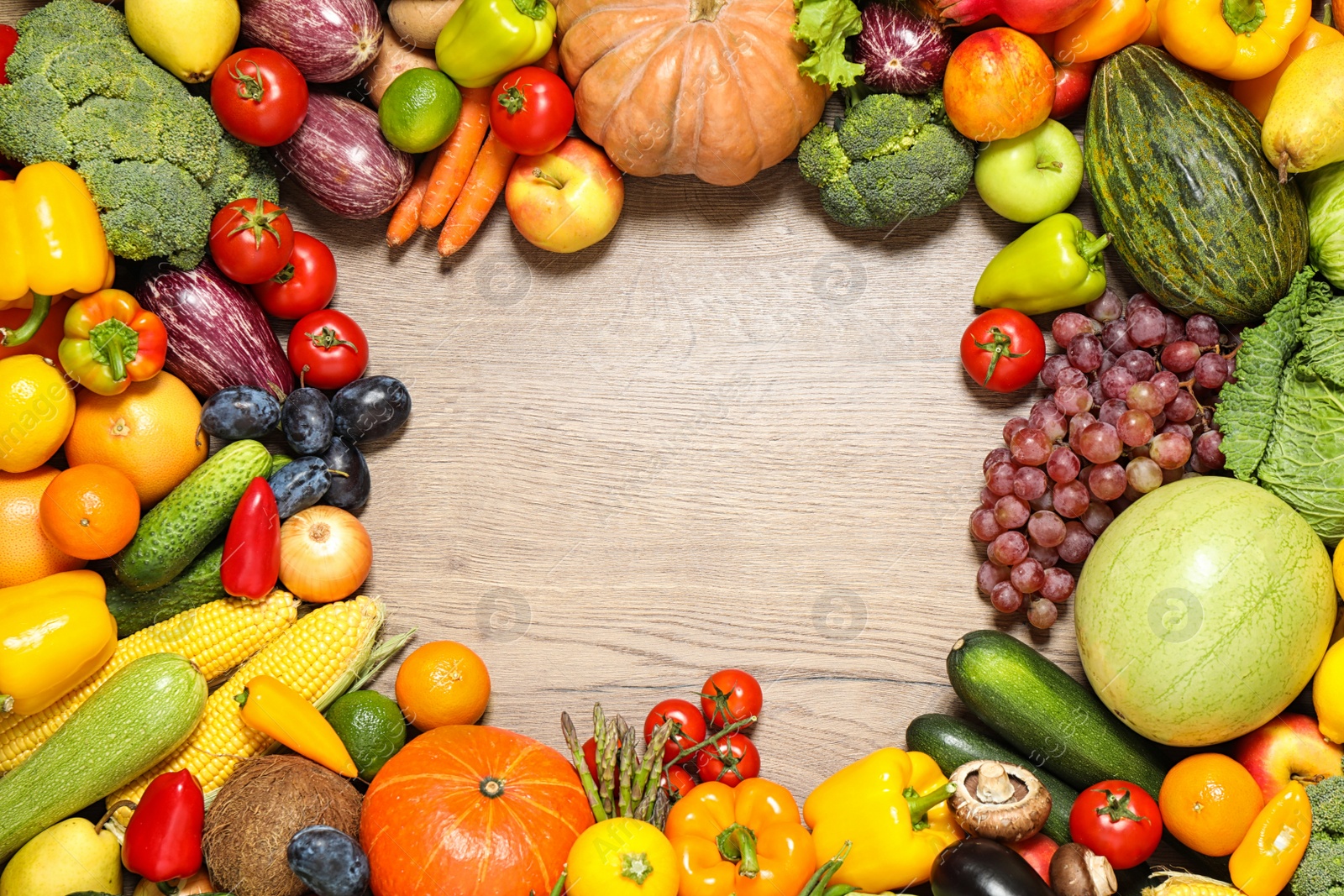 Photo of Frame of assorted fresh organic fruits and vegetables on wooden table, flat lay. Space for text