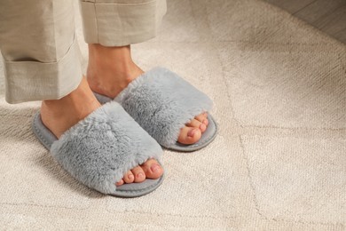 Photo of Woman wearing soft slippers at home, closeup