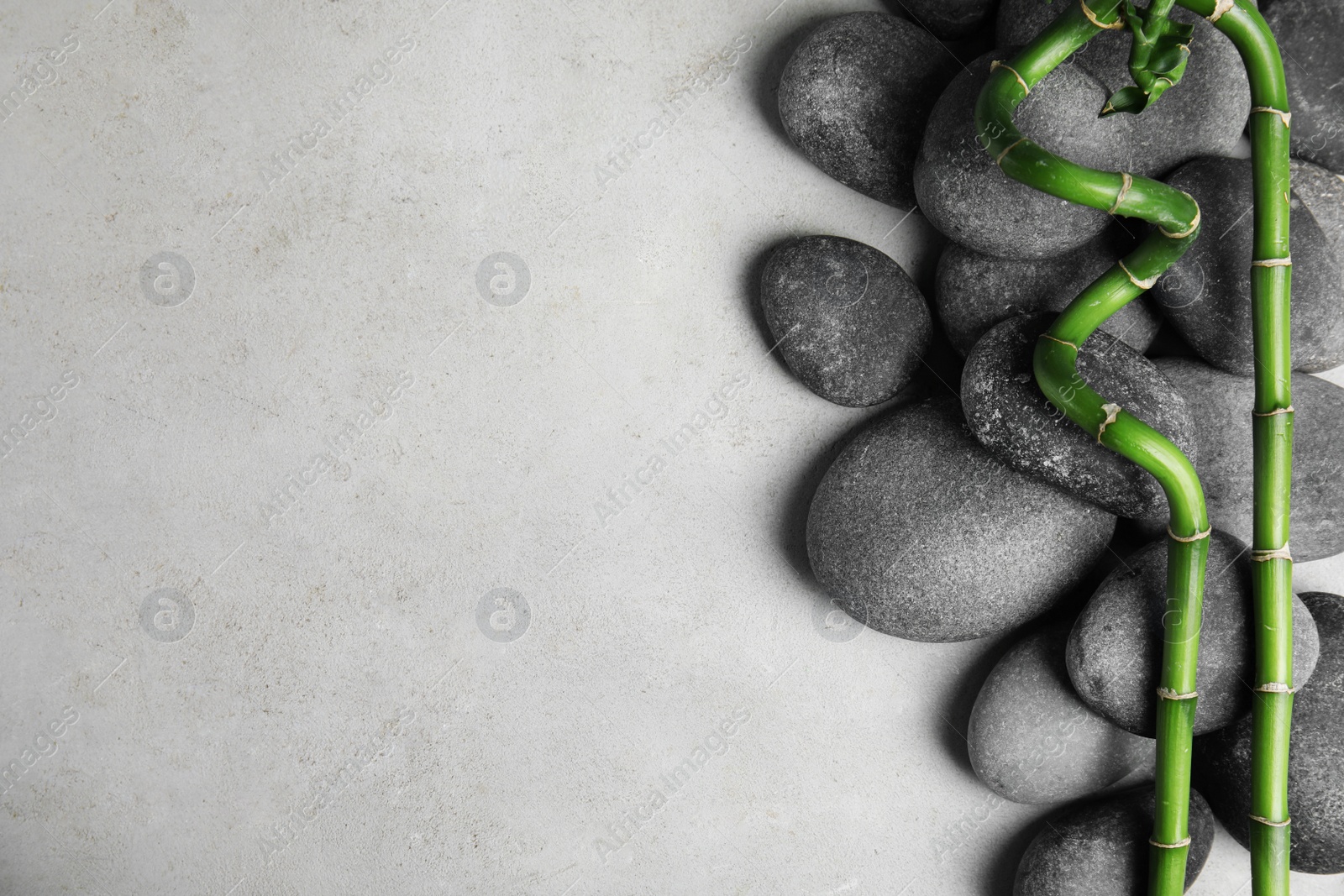 Photo of Zen stones and bamboo on grey background, top view with space for text