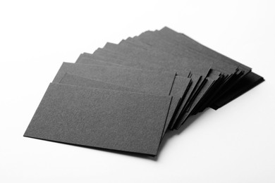 Blank black business cards on white background, closeup. Mockup for design