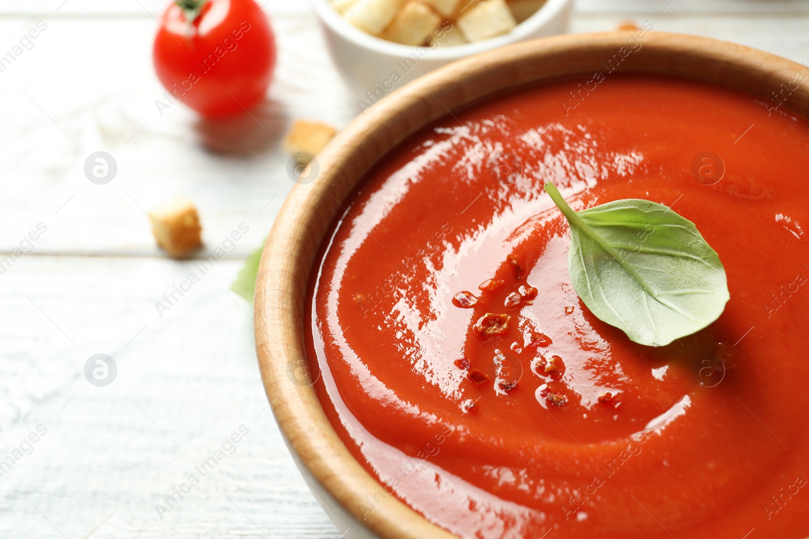 Photo of Bowl with fresh homemade tomato soup on table, closeup. Space for text