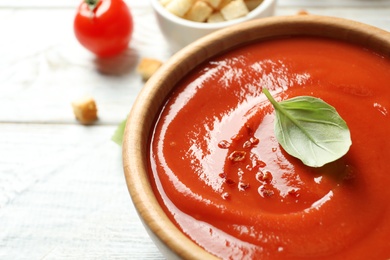 Bowl with fresh homemade tomato soup on table, closeup. Space for text