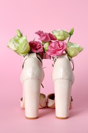 Photo of Stylish women's high heeled shoes with beautiful flowers on pink background