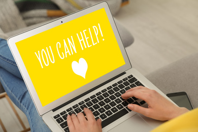 Image of Donations concept. Woman holding laptop with text YOU CAN HELP indoors, closeup