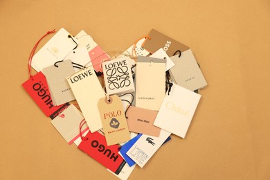 Leiden, Netherlands - December 6, 2023: Heart of different clothing tags on kraft paper sheet, top view