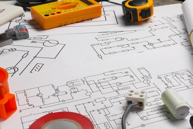 Digital multimeter and other electrician's equipment on wiring diagrams