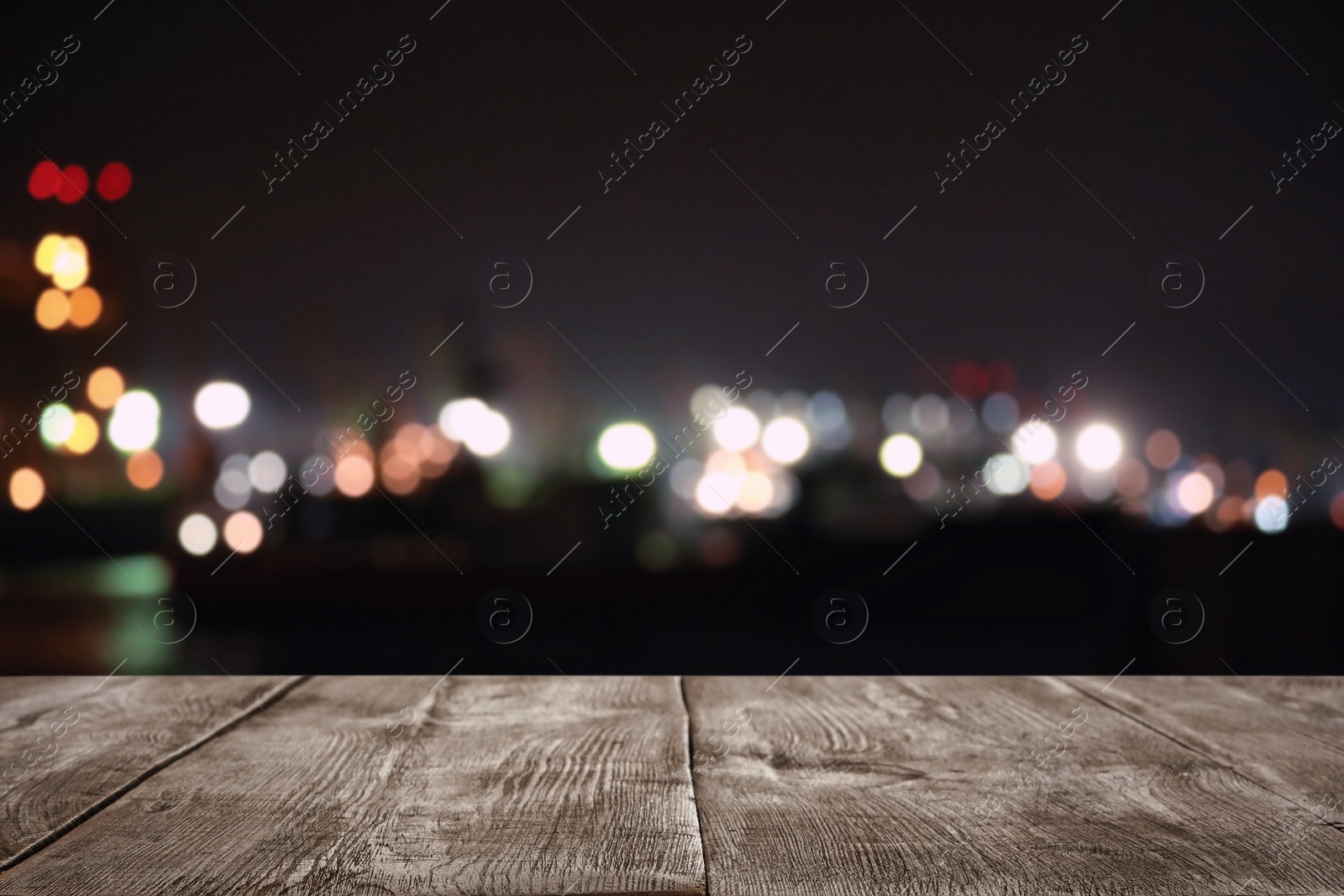 Image of Empty wooden surface and blurred view of night city. Bokeh effect 