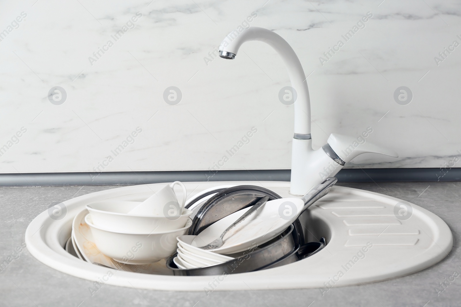 Photo of Messy pile of dirty dishes in sink