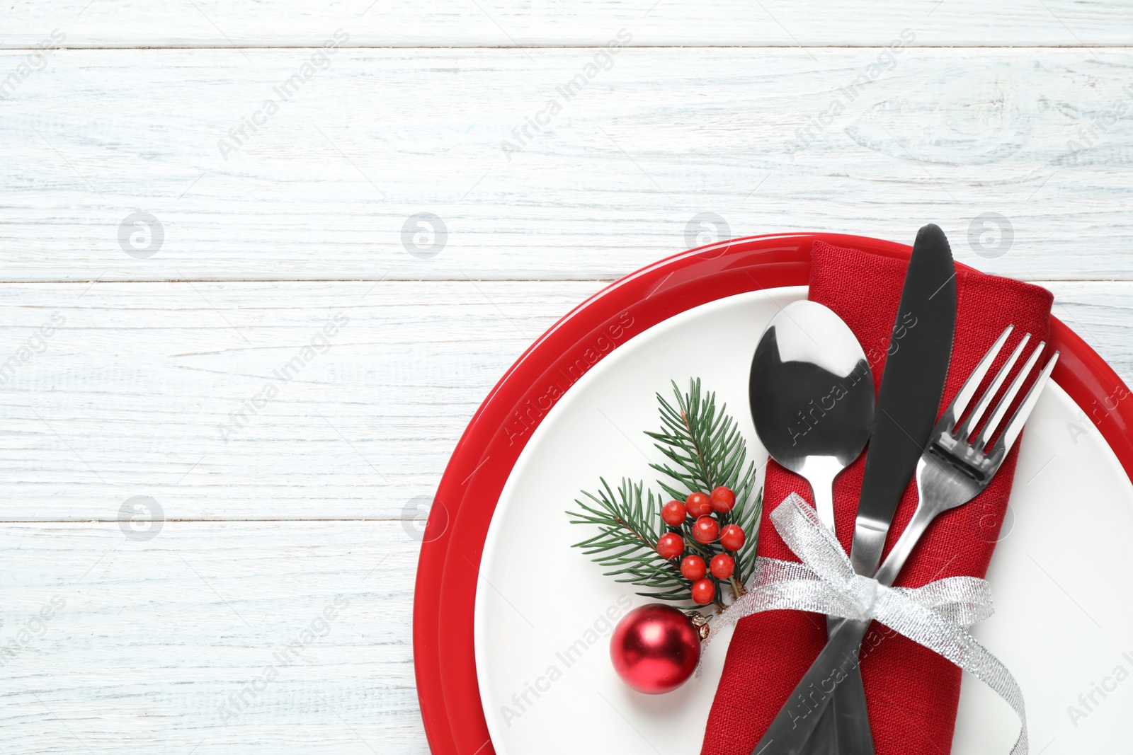 Photo of Christmas table setting on white wooden background, top view. Space for text