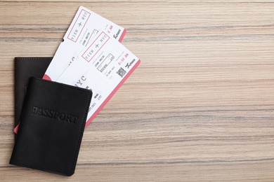 Photo of Avia tickets and passports on wooden table, flat lay with space for text. Travel agency concept