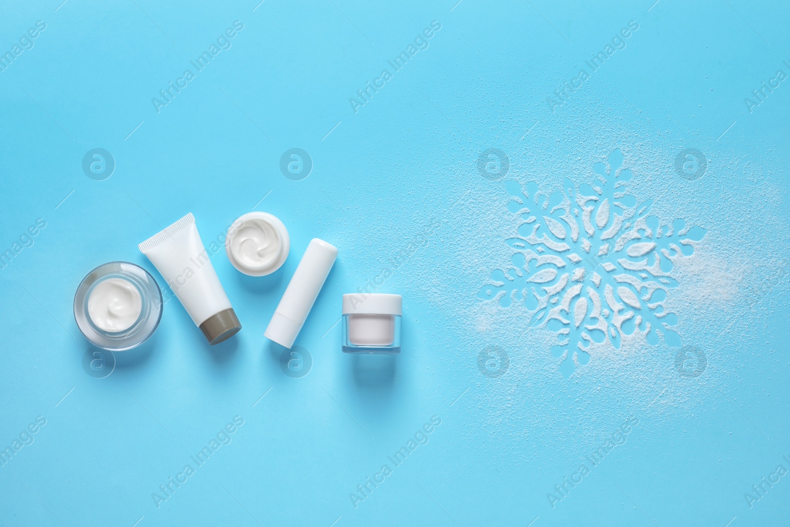 Photo of Set of cosmetic products on blue background, flat lay with space for text. Winter care