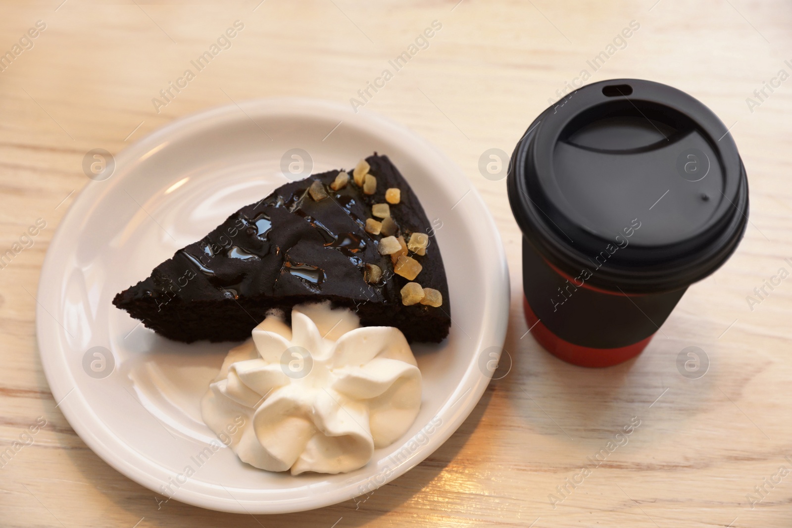 Photo of Tasty coffee in takeaway paper cup and dessert on white wooden table, above view