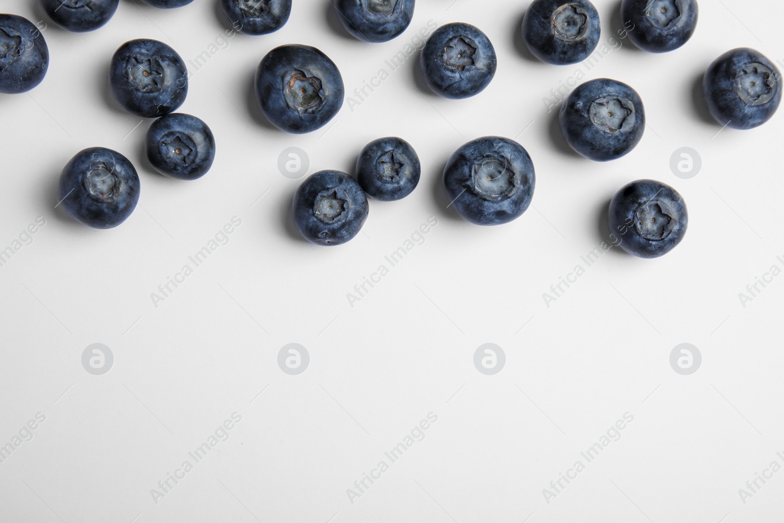 Photo of Tasty ripe blueberries on white background, flat lay