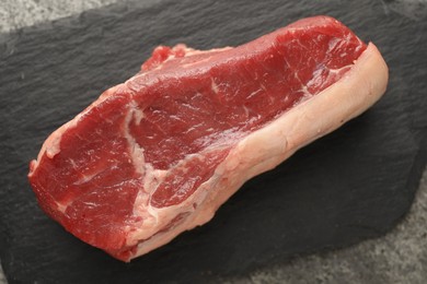 Photo of Piece of raw beef meat on grey table, top view