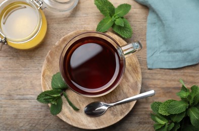Photo of Cup of hot aromatic tea with mint and honey on wooden table, flat lay