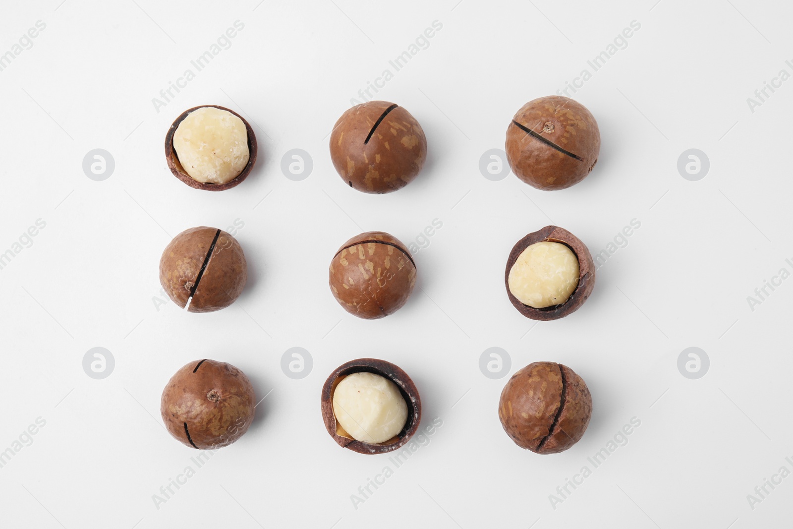 Photo of Tasty Macadamia nuts on white background, flat lay