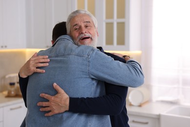 Photo of Happy dad and his son hugging at home