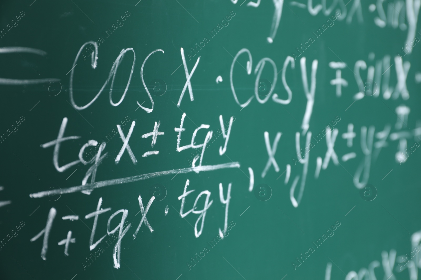 Photo of Many different math formulas written on chalkboard, closeup