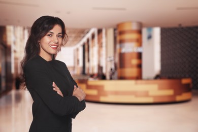 Portrait of hostess wearing uniform in shopping mall. Space for text