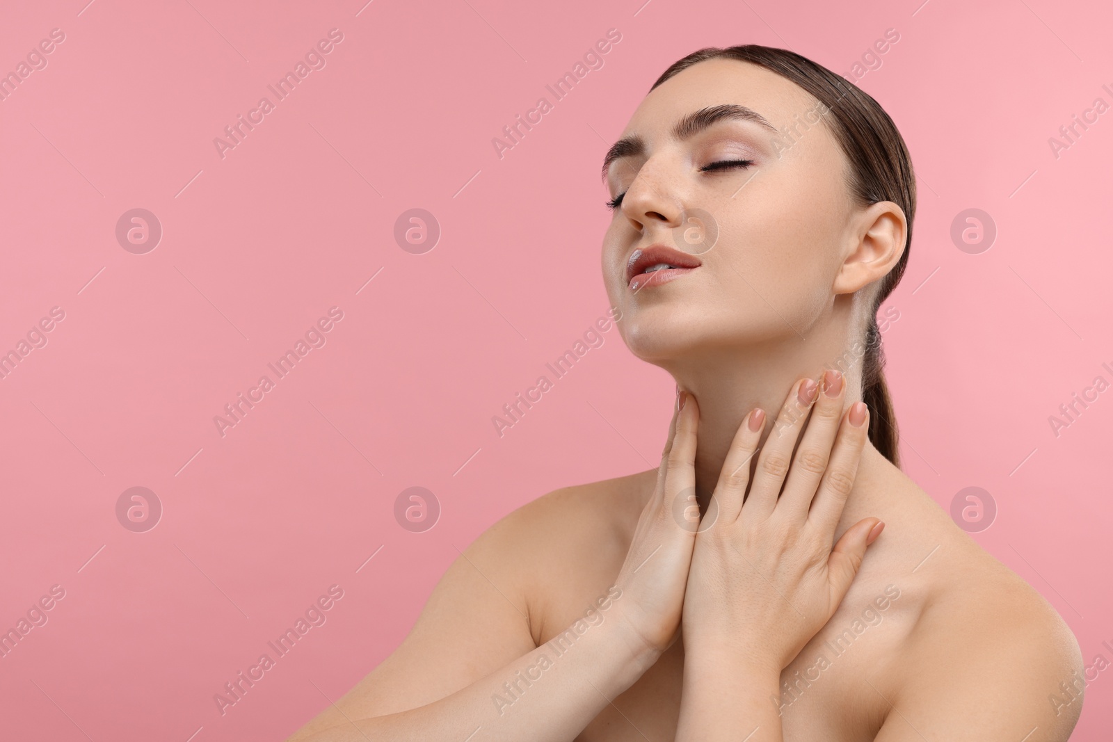 Photo of Beautiful woman touching her neck on pink background. Space for text